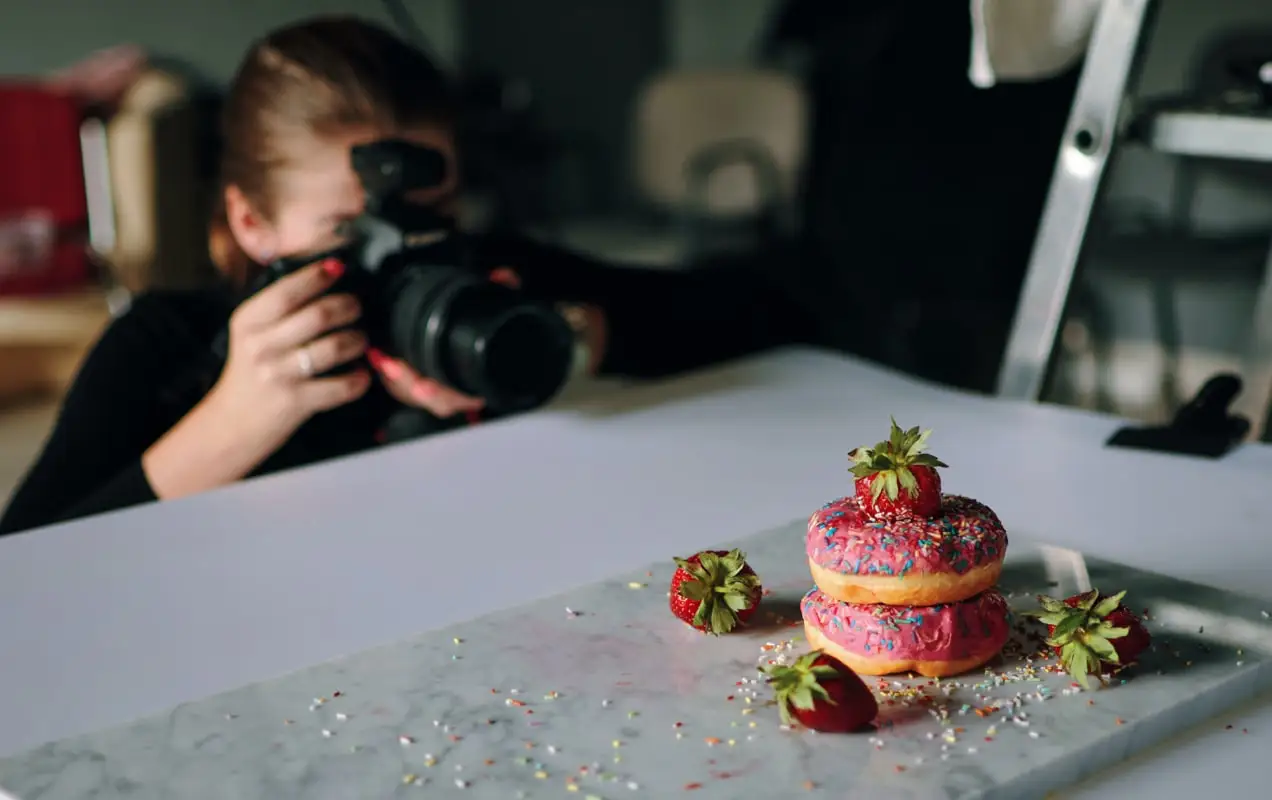 entrepreneur prenant des photos de beignets avec un appareil photo reflex numérique