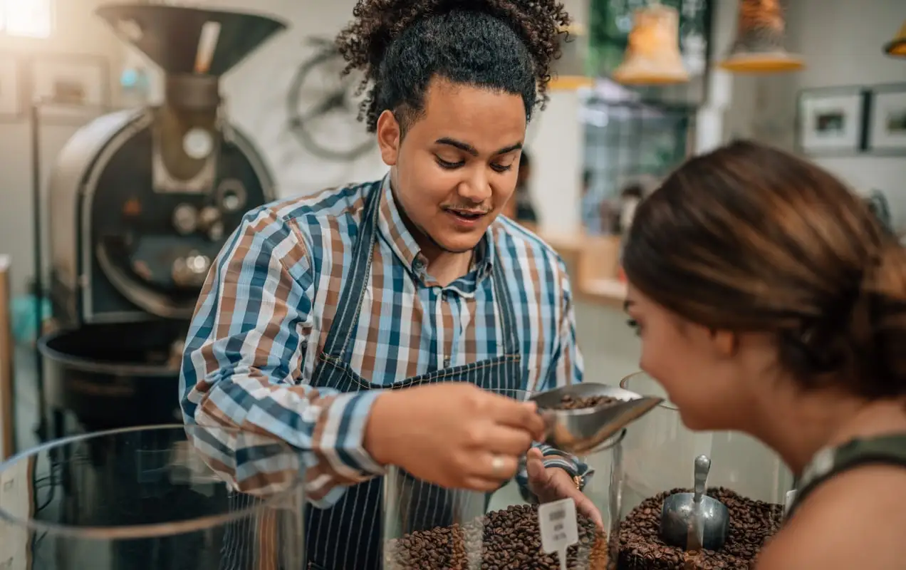 proprietarul unei cafenele care servește cafea unui client