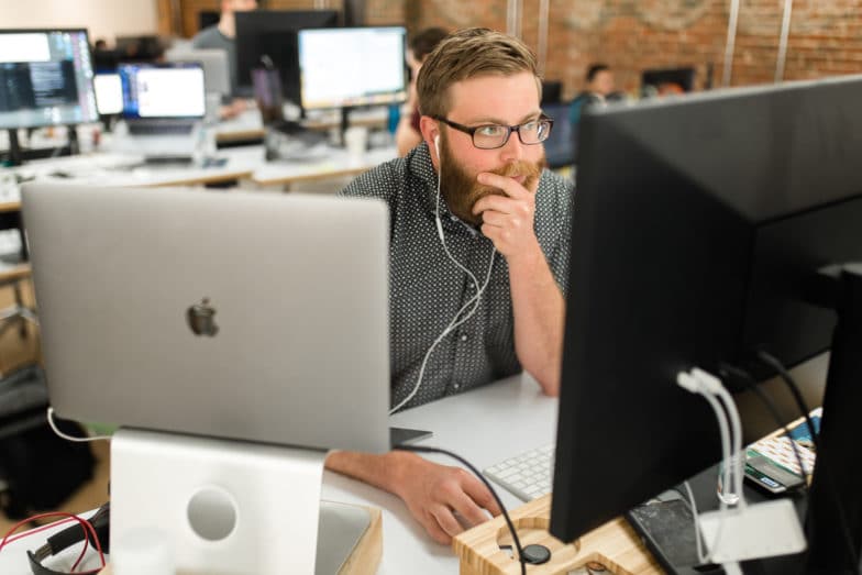 Ein Mann mit Brille blickt nachdenklich auf einen Computerbildschirm