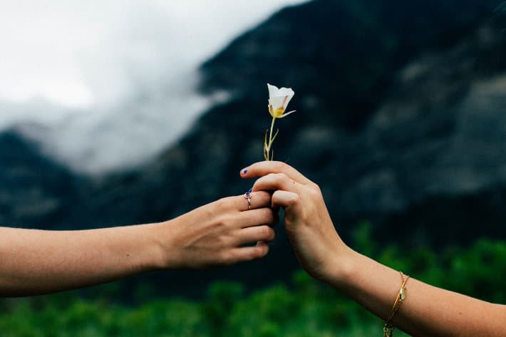 Qualcuno che consegna un fiore a qualcun altro