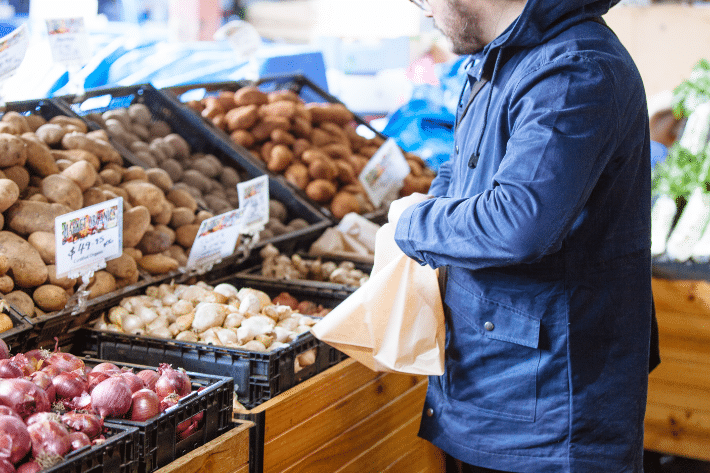 地元の市場で買い物をして、袋ににんにくを入れている人