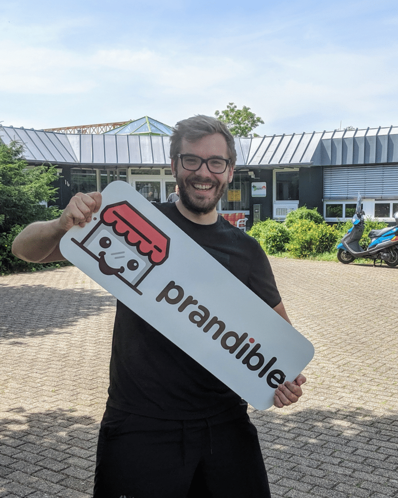 Mann hält Schild mit Prandible-Logo