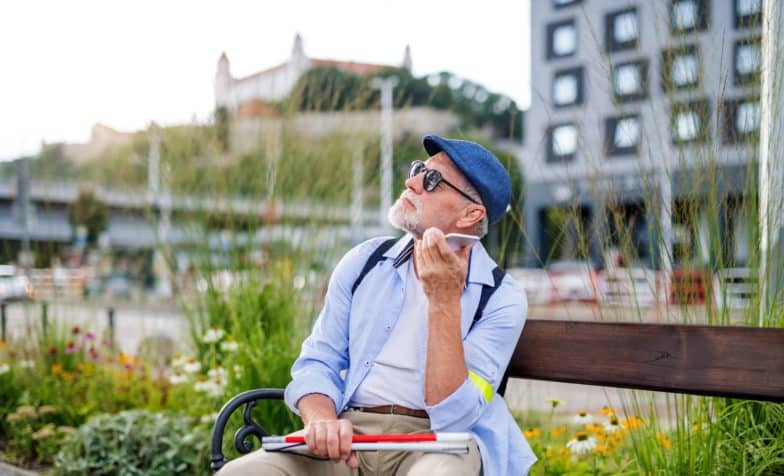 Hombre con discapacidad visual escucha su teléfono