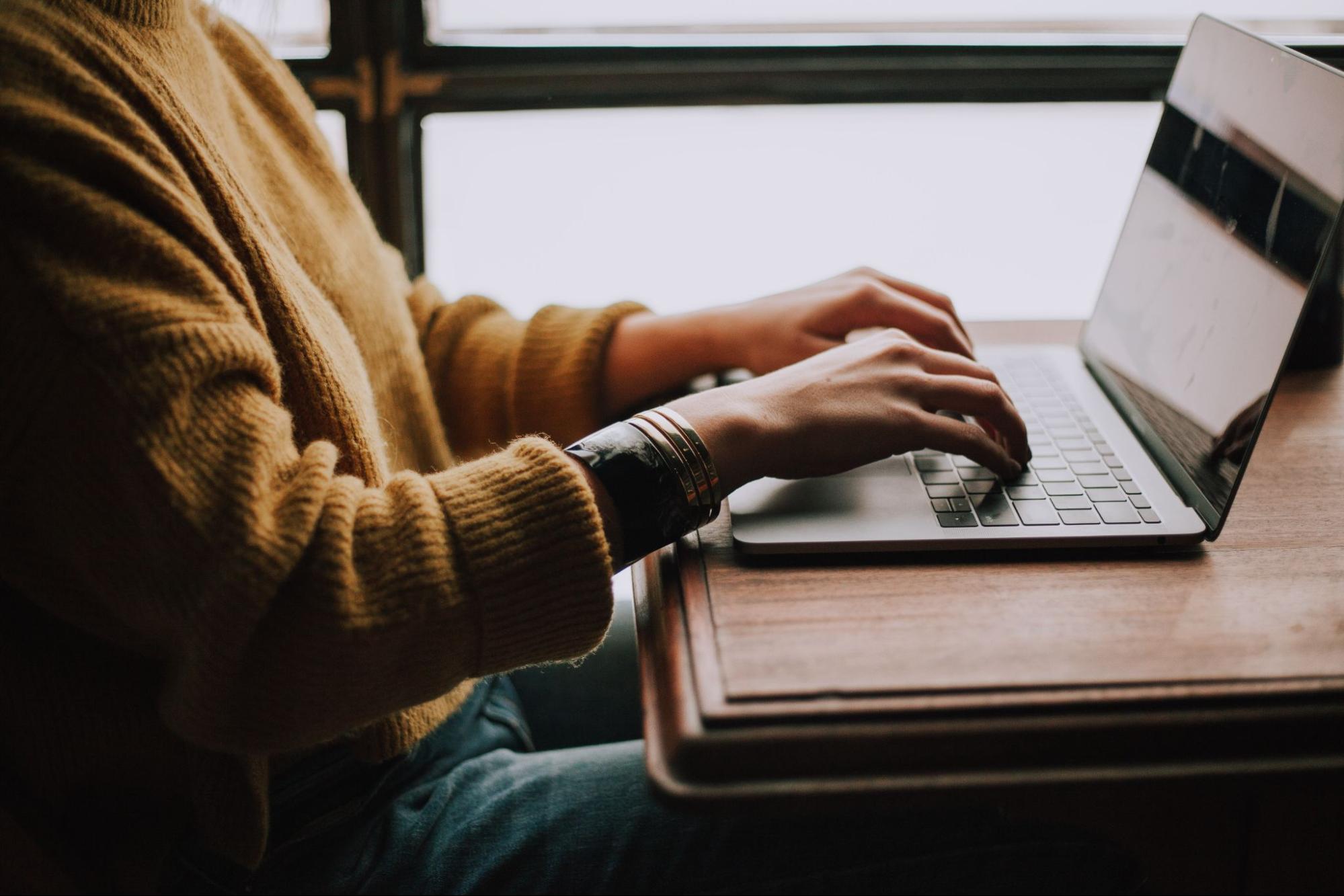 donna che lavora a un tavolo con un computer portatile