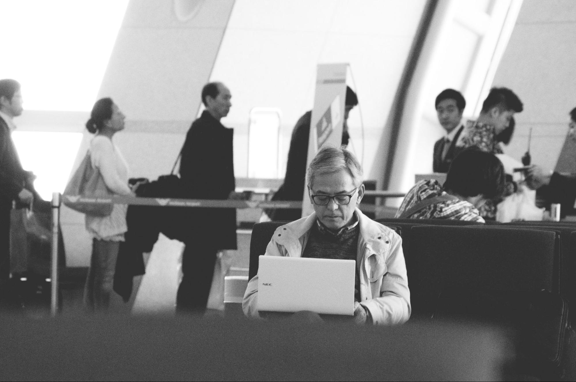 image en noir et blanc d'un homme travaillant sur un ordinateur portable