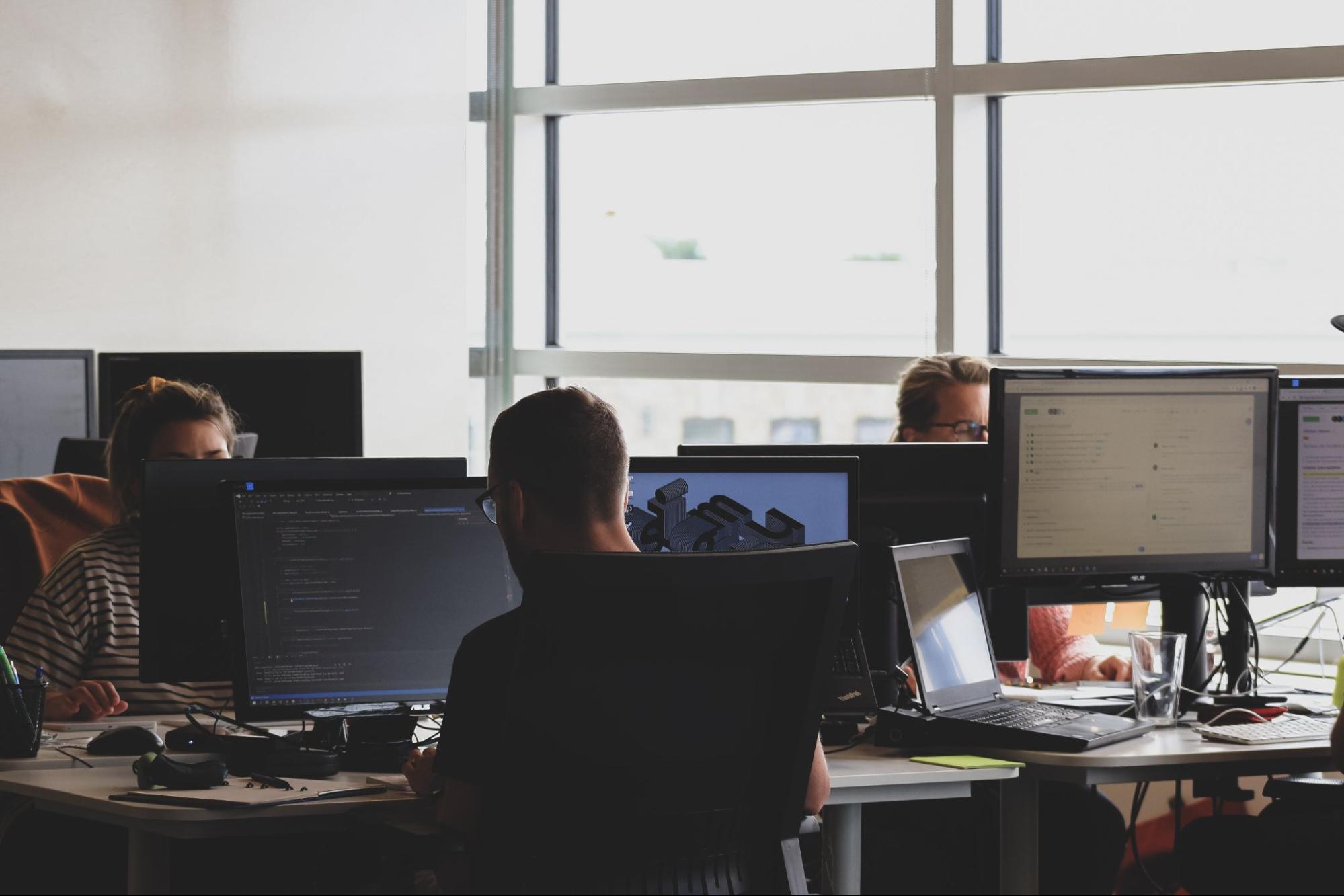 equipe de desenvolvimento trabalhando em computadores