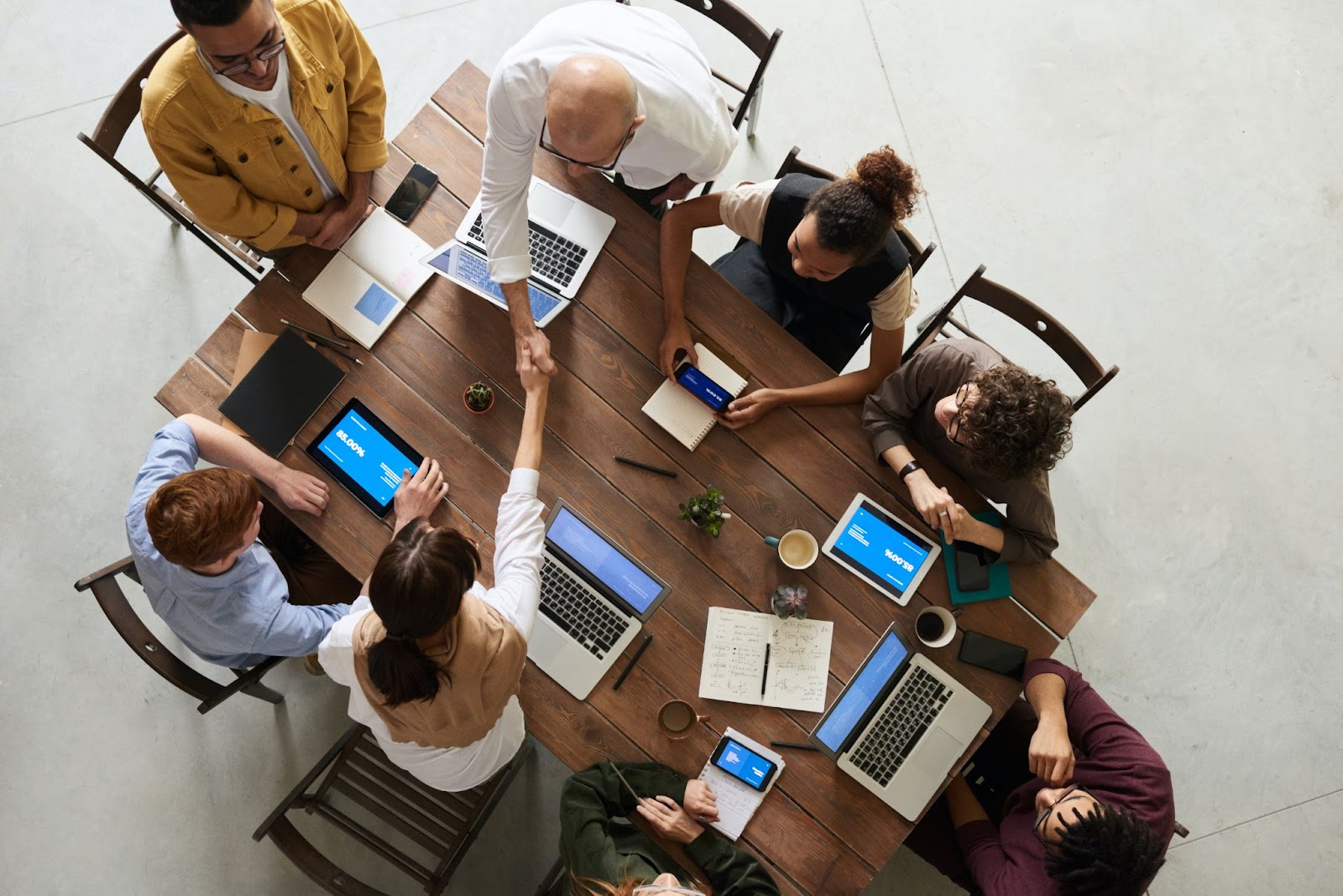 Miembros del equipo reunidos alrededor de una mesa con varios dispositivos.