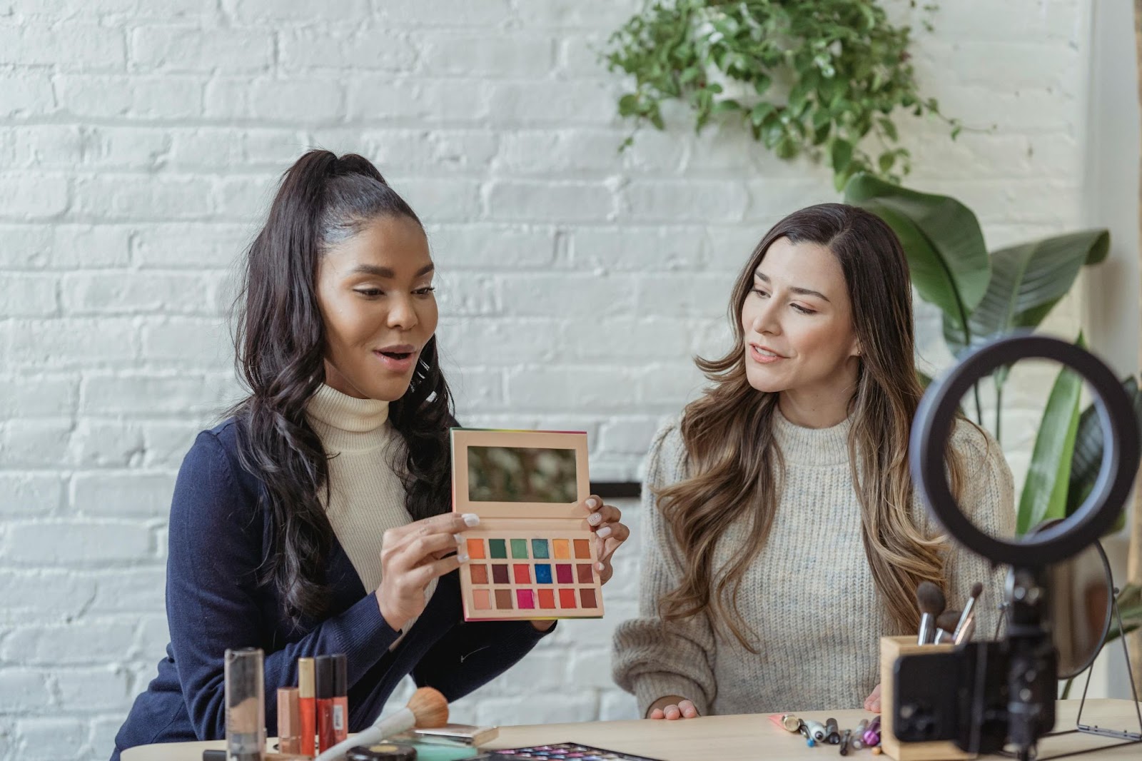 dos mujeres en vivo en las redes sociales y revisando el maquillaje