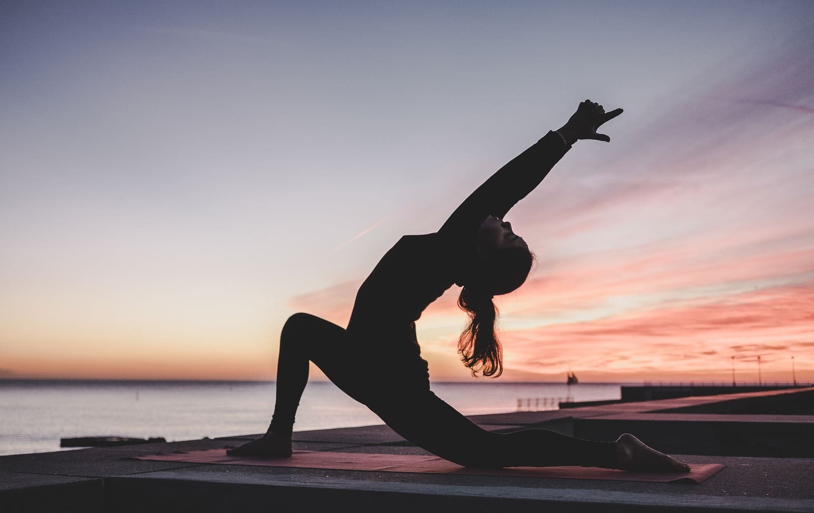 Fotografia di un'attività di yoga sulla spiaggia, uno dei servizi più apprezzati nelle camere d'albergo.