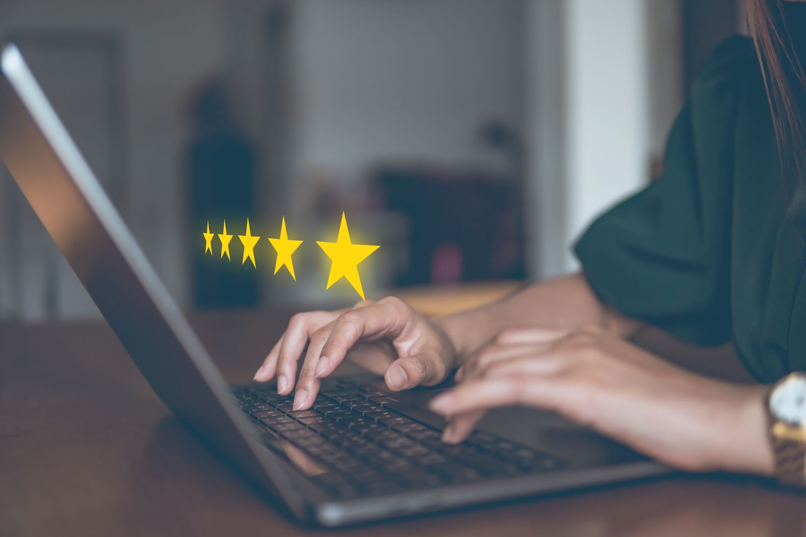 Femme dans un bureau à domicile avec cinq étoiles dorées superposées sur un ordinateur portable.